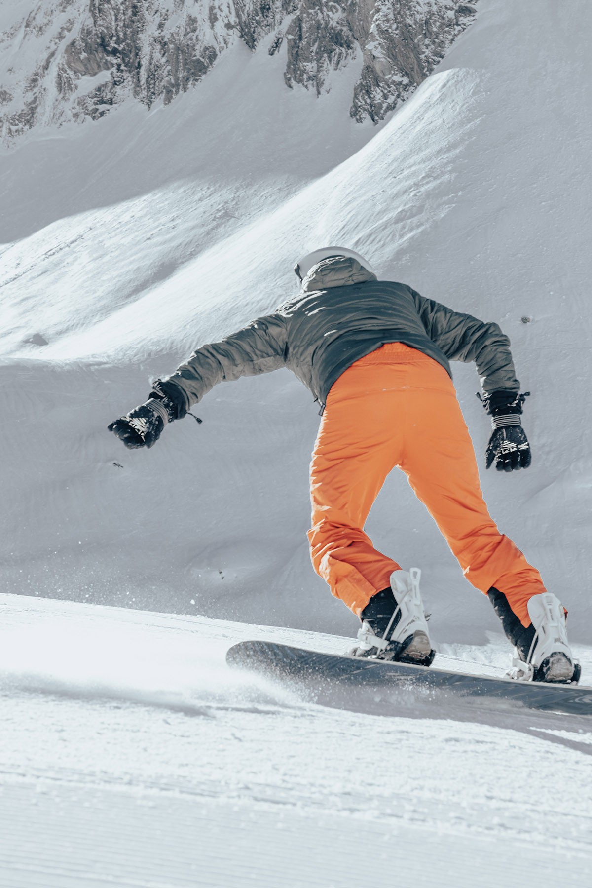 Homme de dos qui glisse avec un snowboard